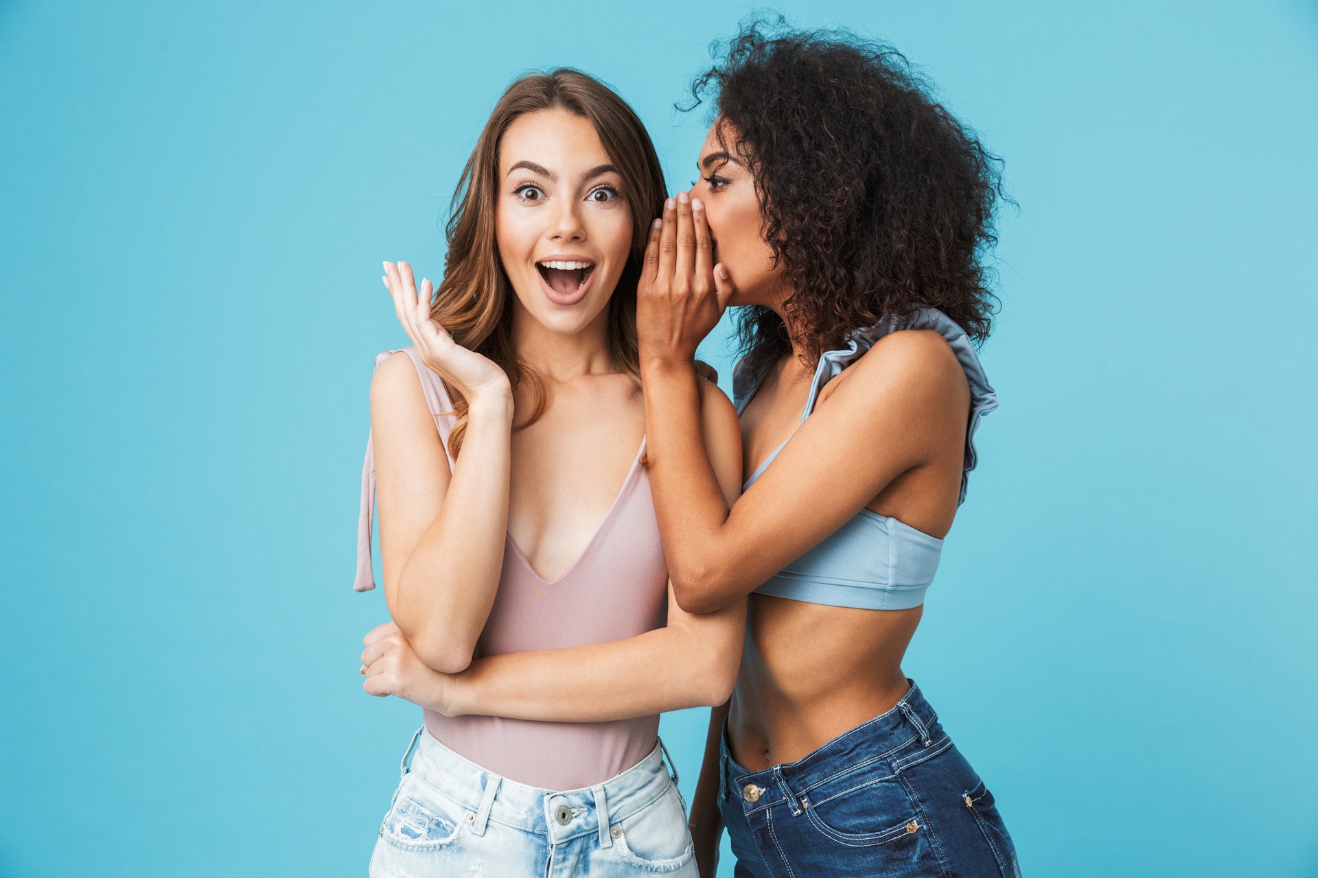 Two cheerful young girls dressed in summer clothes